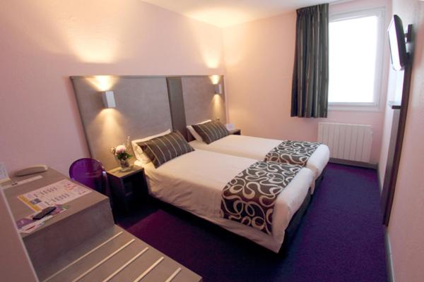 a hotel room with a large bed and a window at Tourhotel Blois in La Chaussée-Saint-Victor