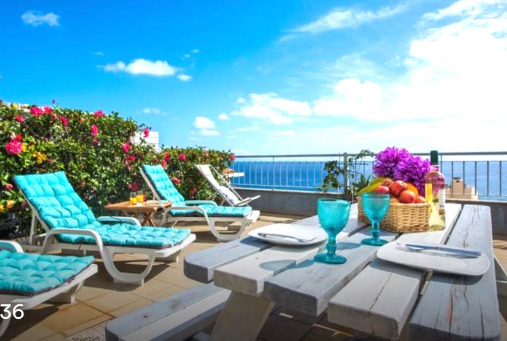 d'une terrasse avec une table et des chaises sur un balcon. dans l'établissement TRIPLEX TERRASSE VUE EXCLUSIVE SUR L OCÉAN ,WIFI, à Santa Cruz