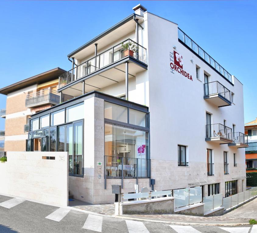 a white building with a sign on it at Hotel Orchidea in Bardolino