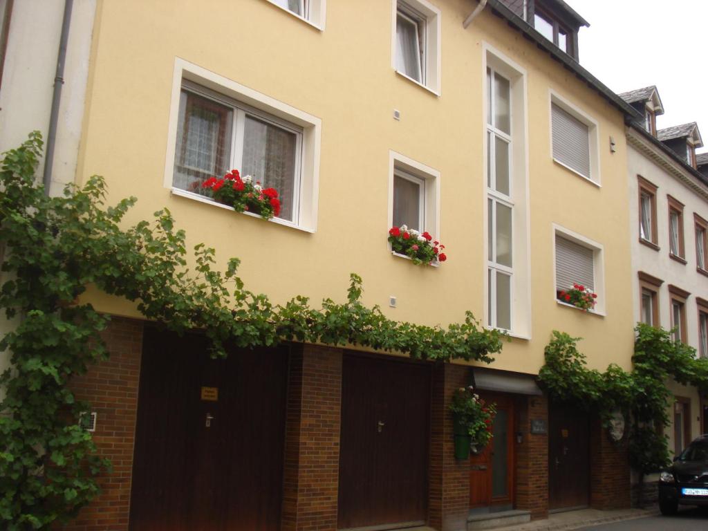 een geel gebouw met rode bloemen in ramen bij Ferienwohnung Lydia in Traben-Trarbach