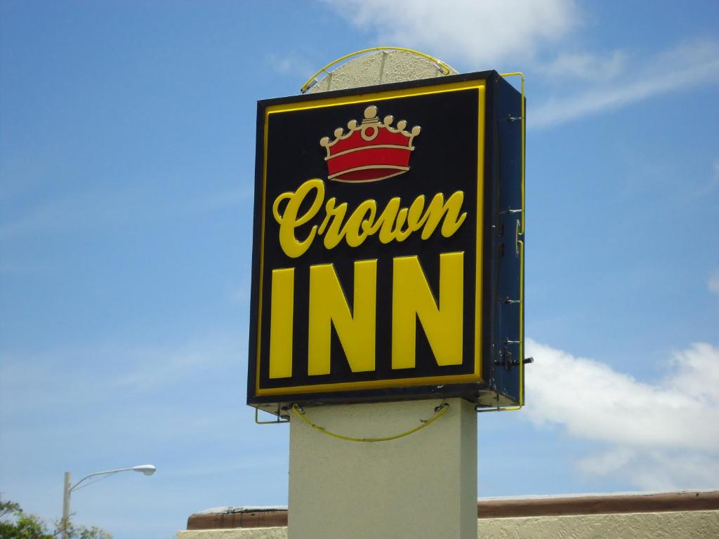 un panneau indiquant une auberge couronnée sur un poteau dans l'établissement Crown Inn, à Fort Lauderdale
