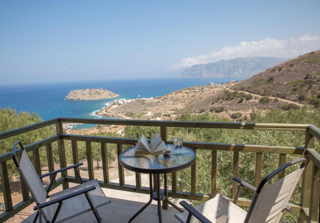 a table and chairs on a balcony with a view of the ocean at Trahilas House in Mochlos