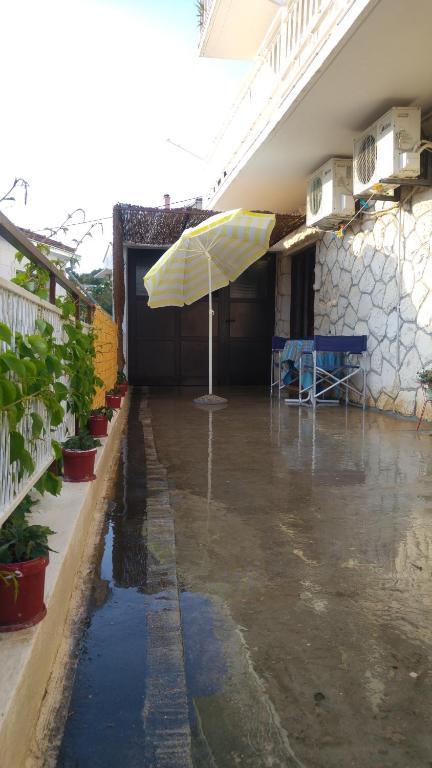 um pátio com um guarda-chuva e uma mesa à chuva em Rooms & Apartments Tepsa - Centre em Hvar