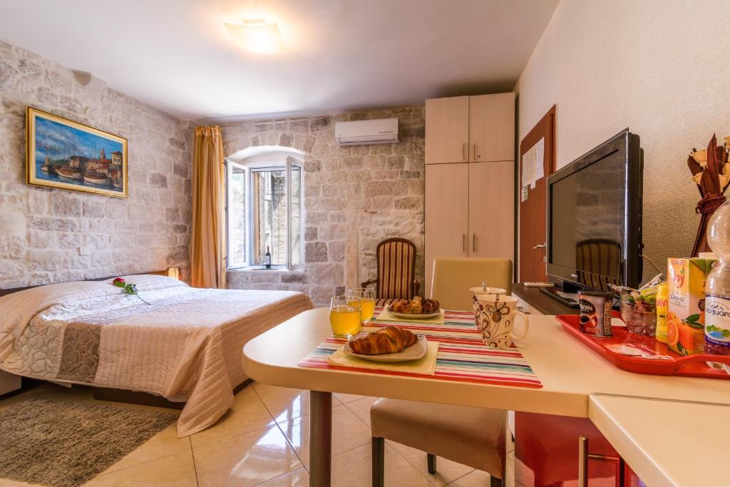 Un dormitorio con una cama y una mesa con comida. en Apartments Dora -Free parking, en Trogir