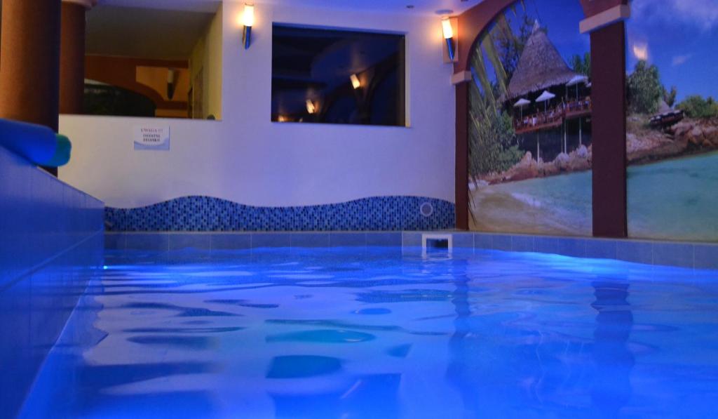 a swimming pool with blue lights in a house at Tropikalna Odnowa in Fałkowo