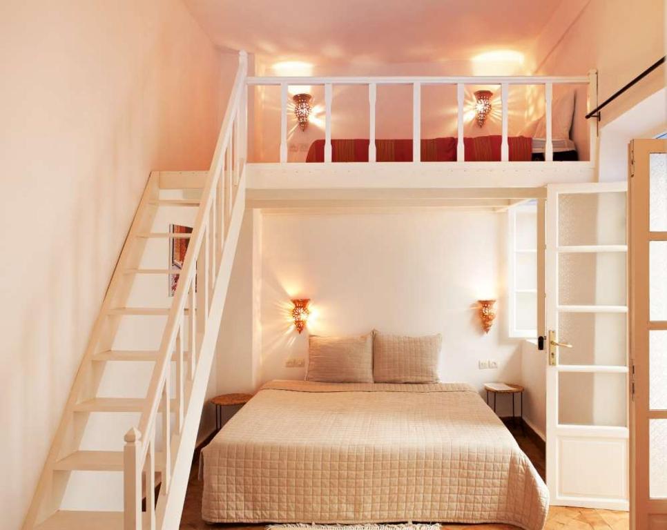 Un pequeño dormitorio con una cama y una escalera en La Casa Del Mar en Essaouira