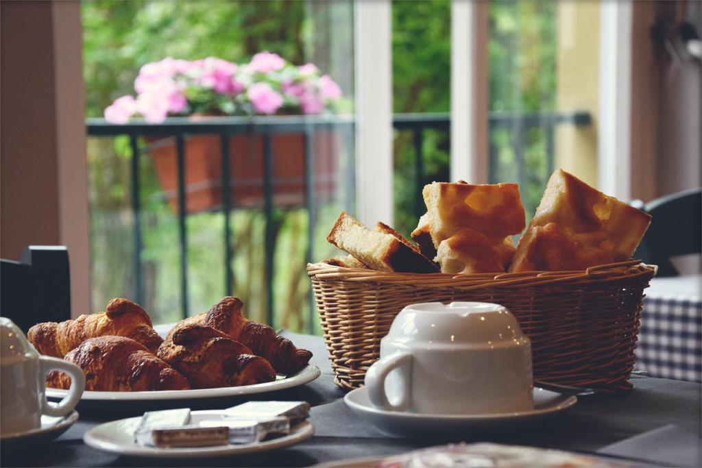 - un panier de pain et un panier de viennoiseries sur une table dans l'établissement Pineta del Borgo, à Cavi di Lavagna