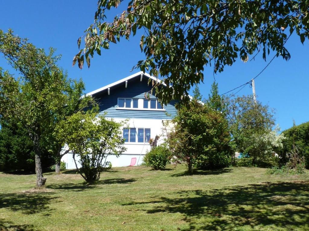 una casa blanca con árboles delante de ella en La Maison Bel'Air en Gérardmer