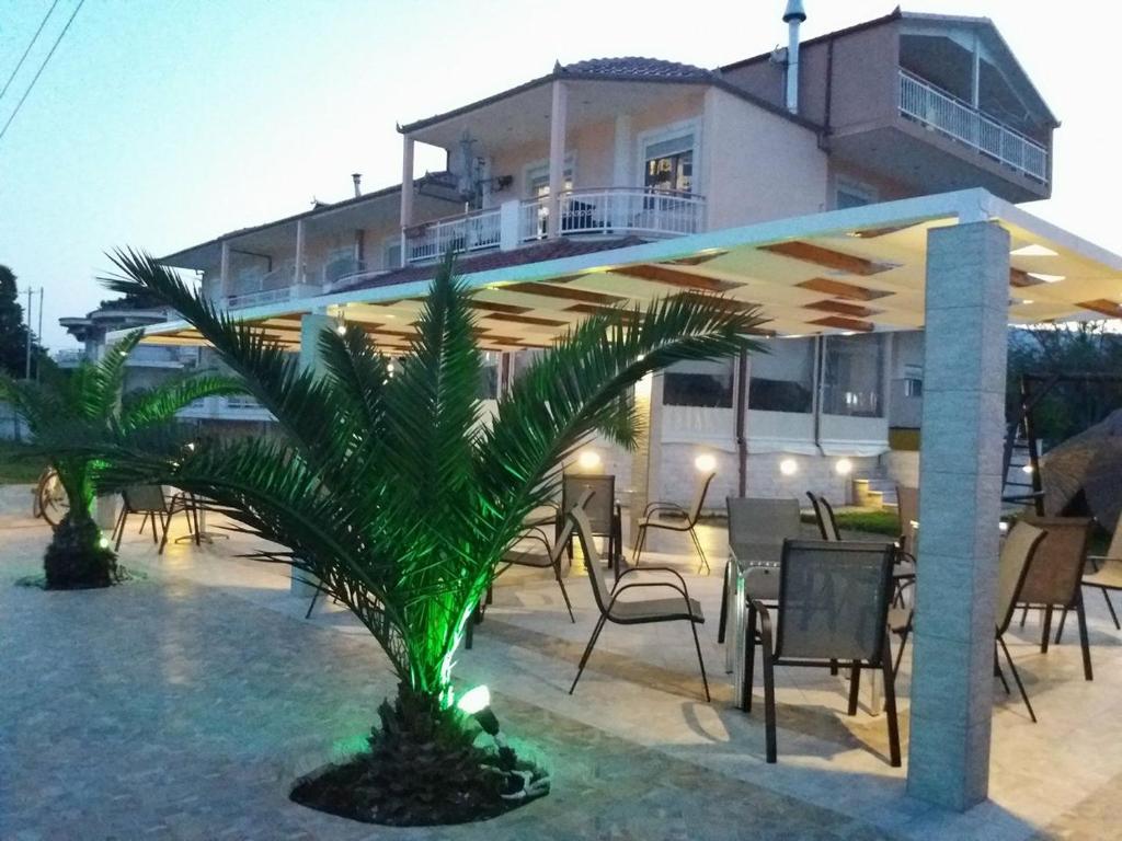 a house with a palm tree in front of it at Pension Delfini in Asprovalta