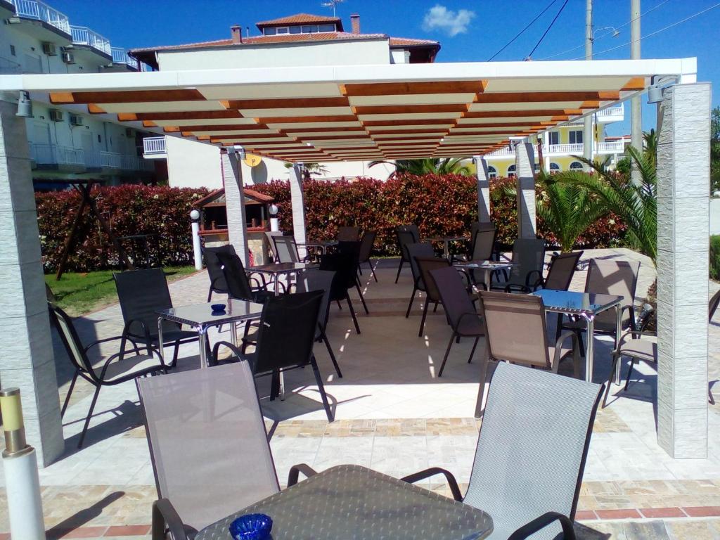 a patio with tables and chairs under a pavilion at Pension Delfini in Asprovalta
