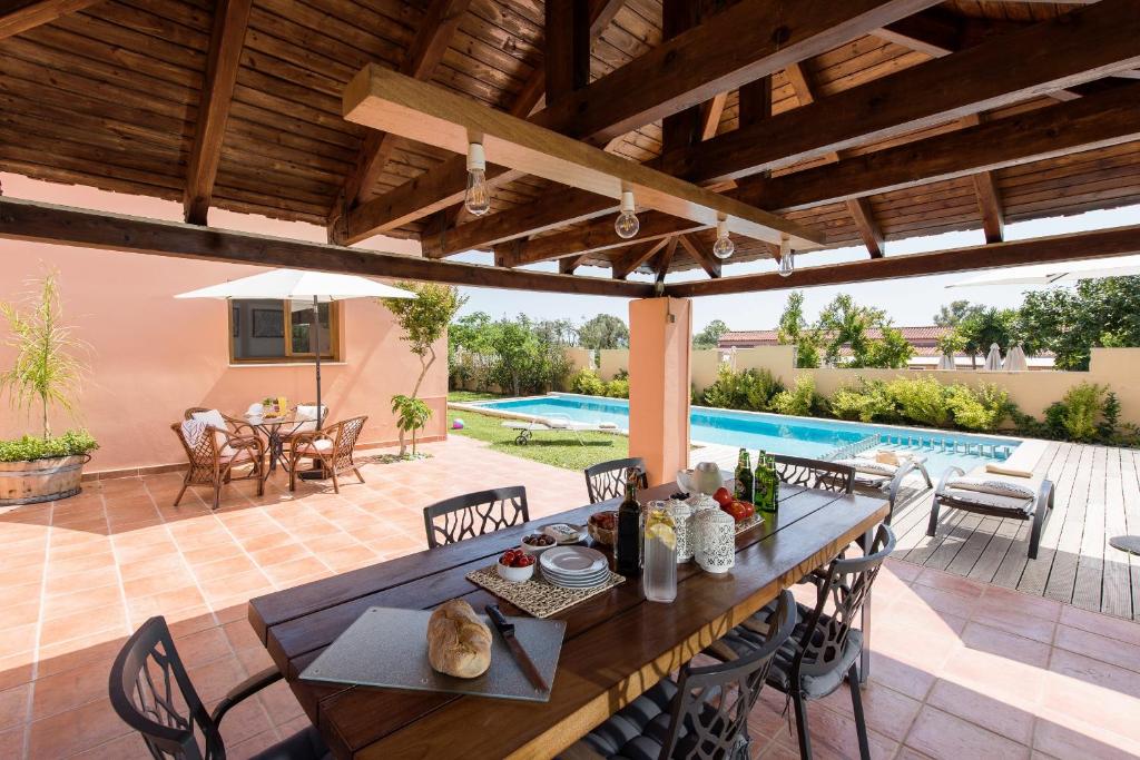 a patio with a table and chairs and a swimming pool at Villa Filoxenia 1937 in Gerani Chanion