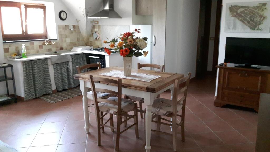 una cucina con tavolo e vaso di fiori di La casina negli orti ad Arcola