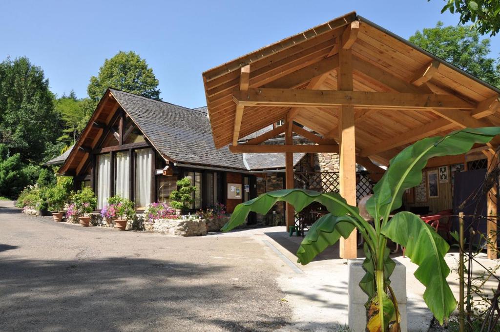 un edificio con un pabellón de madera delante de él en Camping jardin La Vie en Vert en Ariège, en Augirein