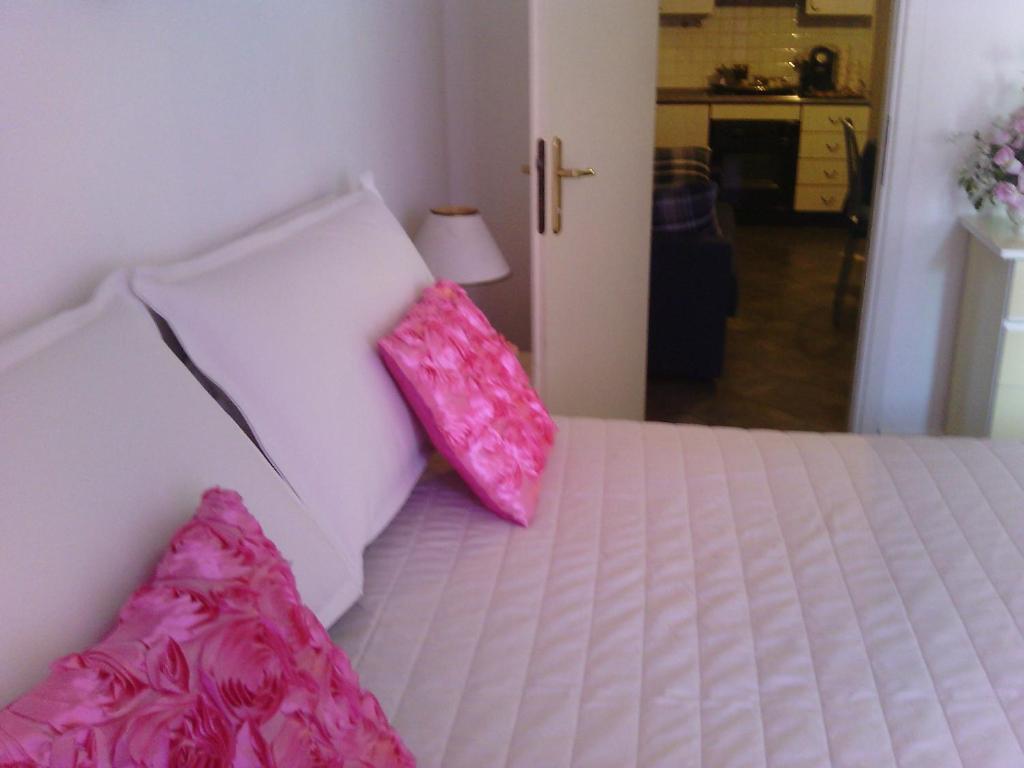 una camera da letto con un letto con cuscini rosa di Appartamento Libertà a Portovenere