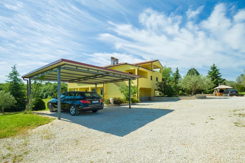 un coche aparcado frente a una casa amarilla en Apartments Terranova, en Rovinj