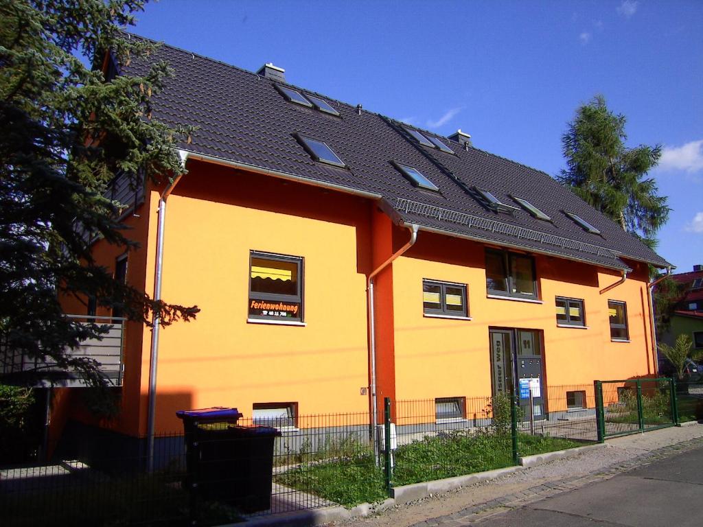 a yellow and orange house with a black roof at Ferienwohnungen Uhlemann - nur 15 Minuten bis in die Altstadt in Dresden