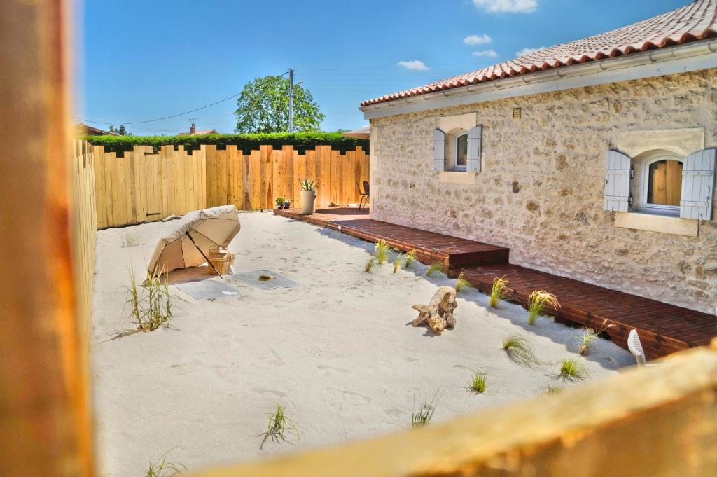 un patio trasero con un edificio y una valla de madera en Villa l'estuaire Gîte, en Braud-et-Saint-Louis