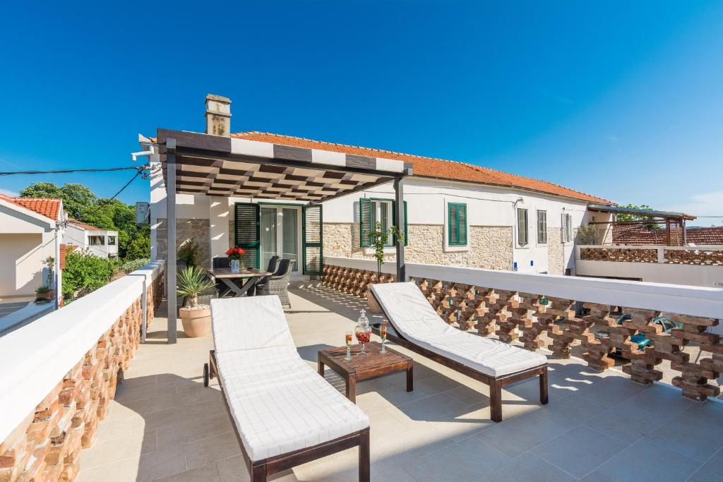 - une terrasse avec 2 chaises et un kiosque dans l'établissement Apartments Fontana, à Zadar