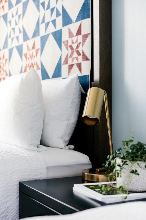 a bedroom with a bed and a table with a lamp at Mount Royal Hotel in Banff