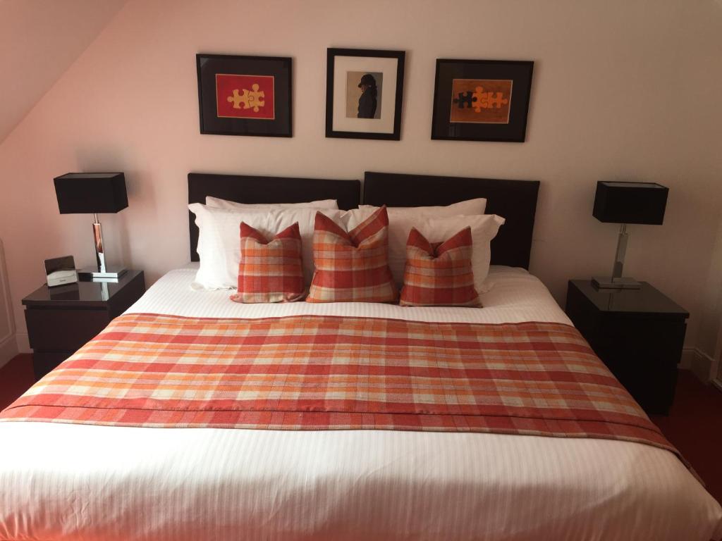 a bedroom with a bed with red and white pillows at The Golden Larches in Lochearnhead