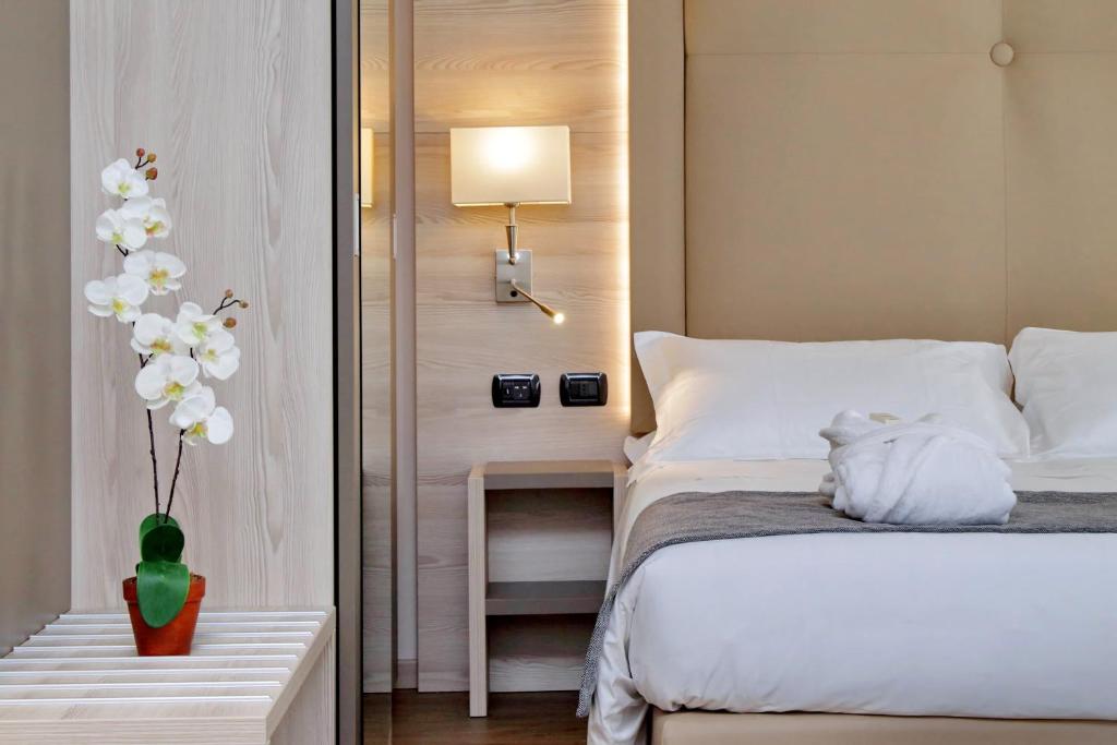 
a bed room with a white bedspread and a white dresser at Duomo Hotel & Apartments in Milan
