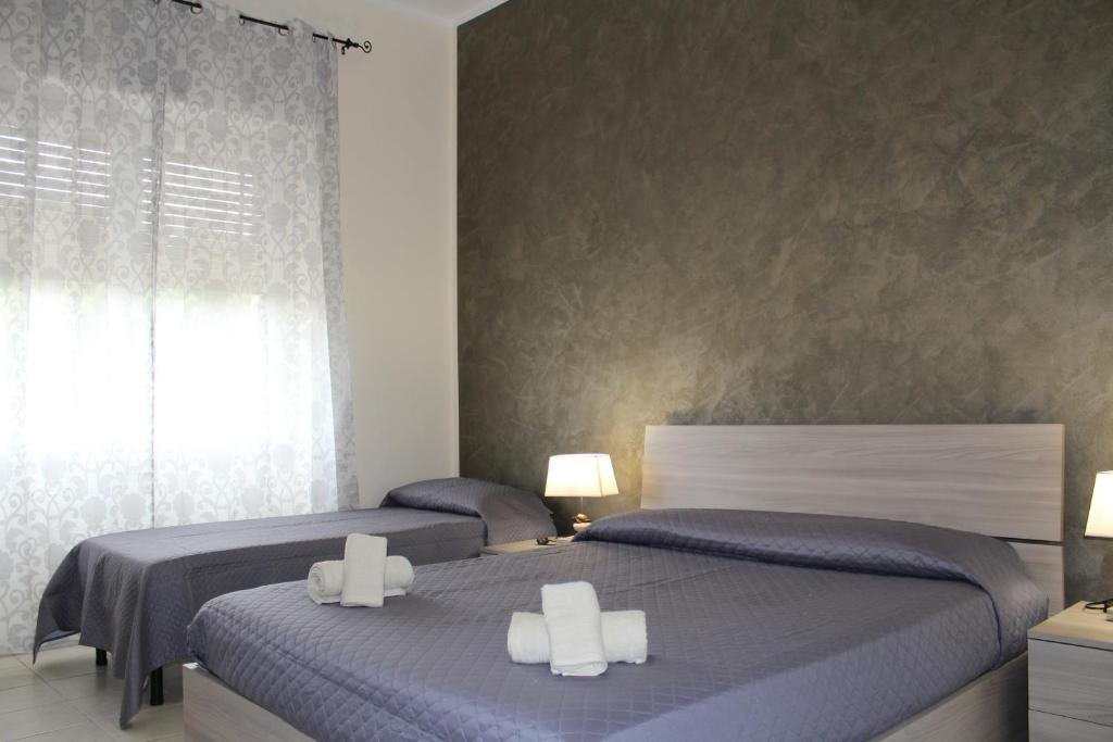 a bedroom with two beds and a window at Cagliari 4u Self Check in in Cagliari