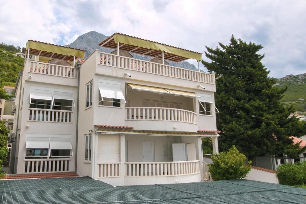 Casa blanca grande con balcones y árboles en Apartments Sanda 2, en Promajna