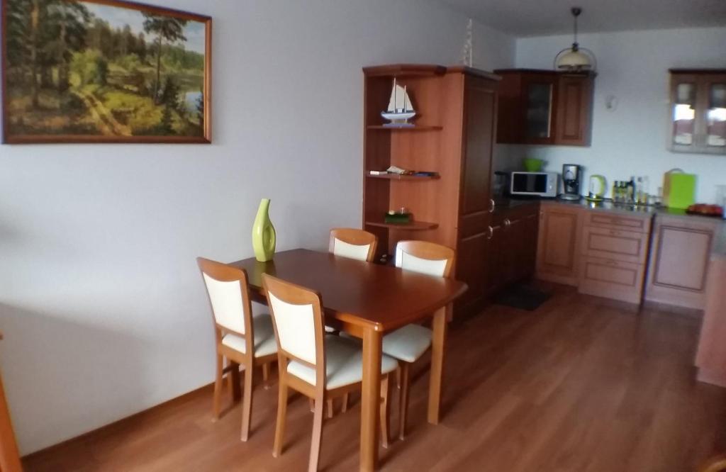 グジボボにあるApartament 2 pokoje Osiedle Bałtyk Grzybowo Piaskowaのキッチン、ダイニングルーム(木製のテーブルと椅子付)