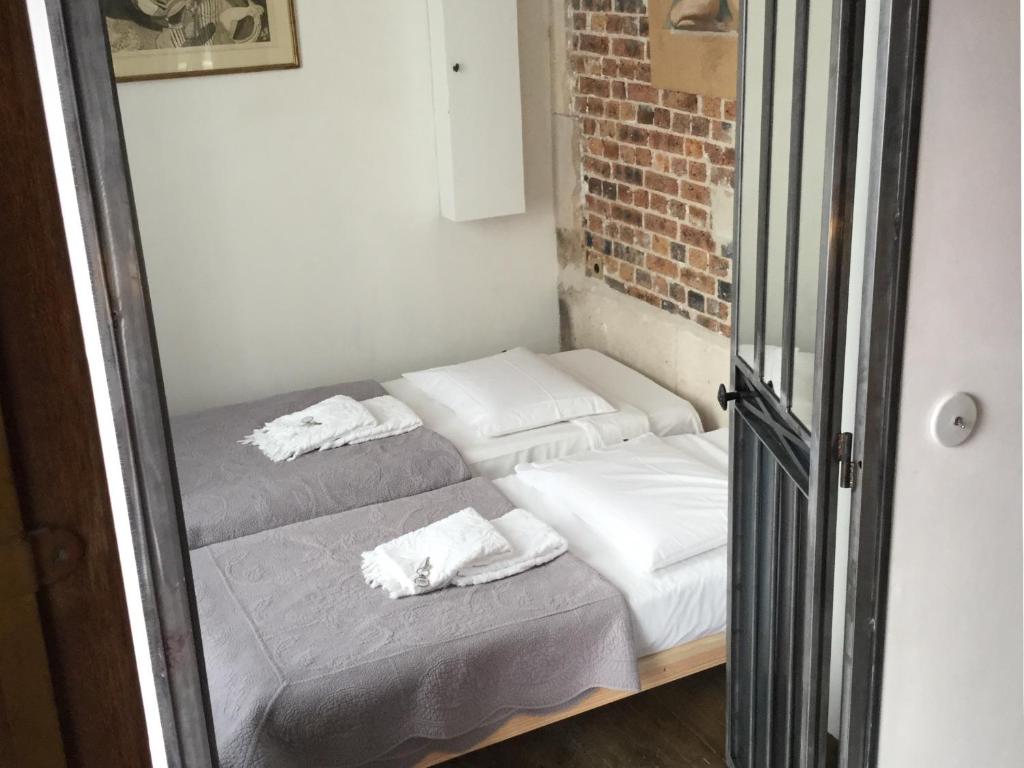 two beds in a room with a mirror at Cluny La Sorbonne Paris in Paris