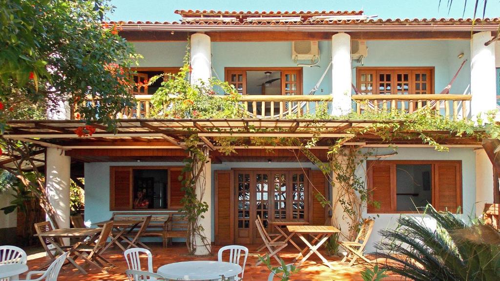 una casa con terrazza e tavoli e sedie di Pousada Manaca a Abraão