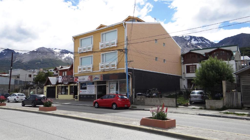 un coche rojo estacionado frente a un edificio en una calle en Mi Segunda Casa en Ushuaia