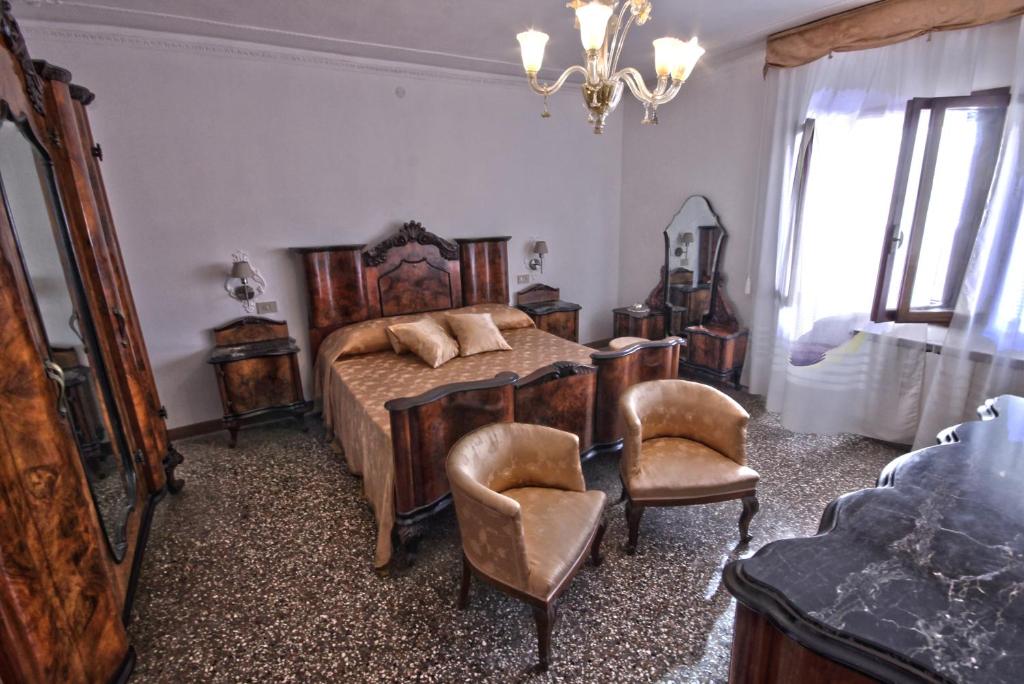 a bedroom with a bed and a table and chairs at CasaGiulietta in Venice