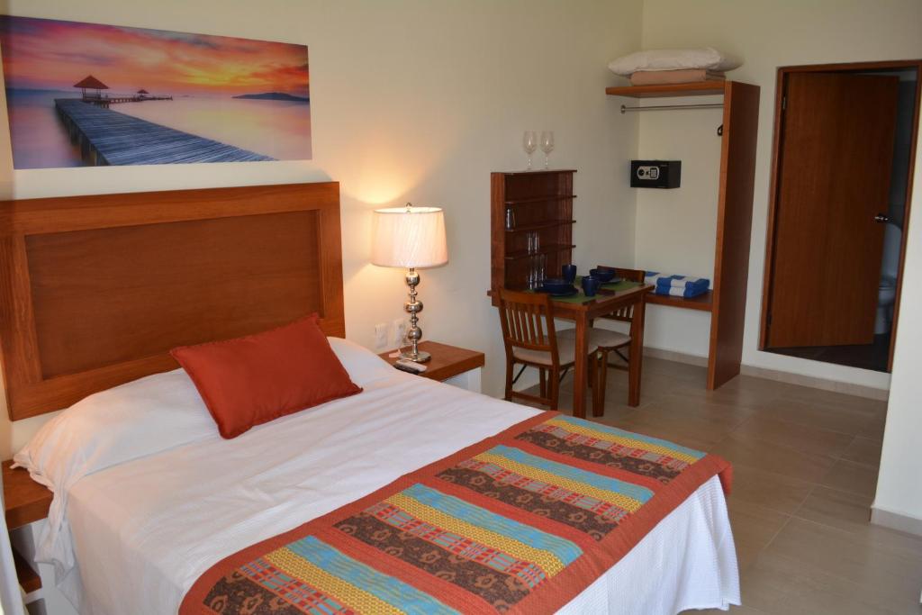 1 dormitorio con 1 cama y mesa con escritorio en Suites SanRey, en Puerto Morelos
