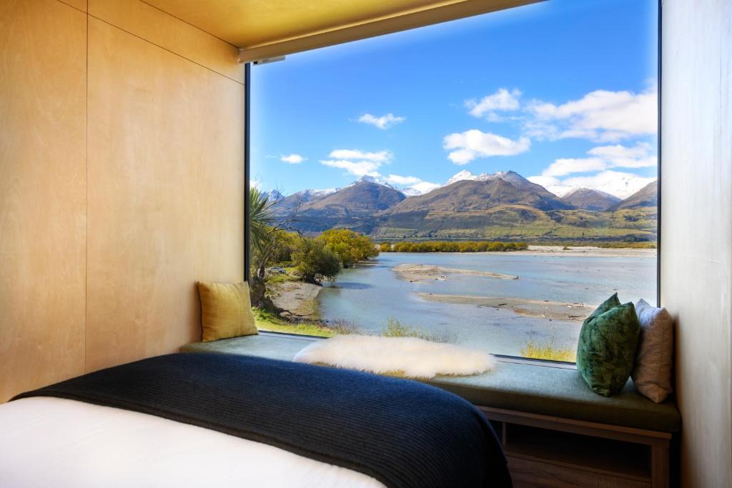 a bedroom with a window with a view of a river at EcoScapes in Glenorchy