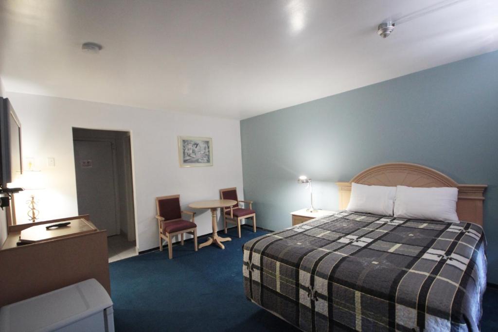 a hotel room with a bed and a table and chairs at 6267 Persepolis Inn in Niagara Falls