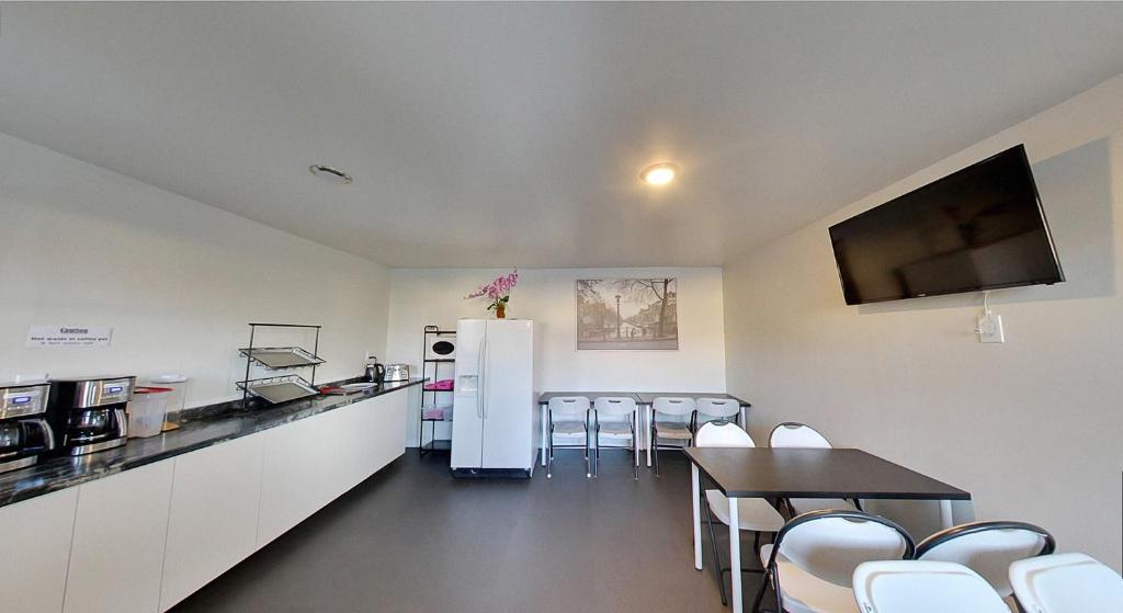 a kitchen with a refrigerator and a table and chairs at 6267 Persepolis Inn in Niagara Falls