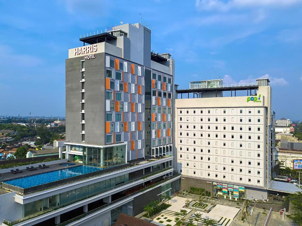 un hotel con piscina frente a un edificio en HARRIS Hotel & Conventions Solo en Solo