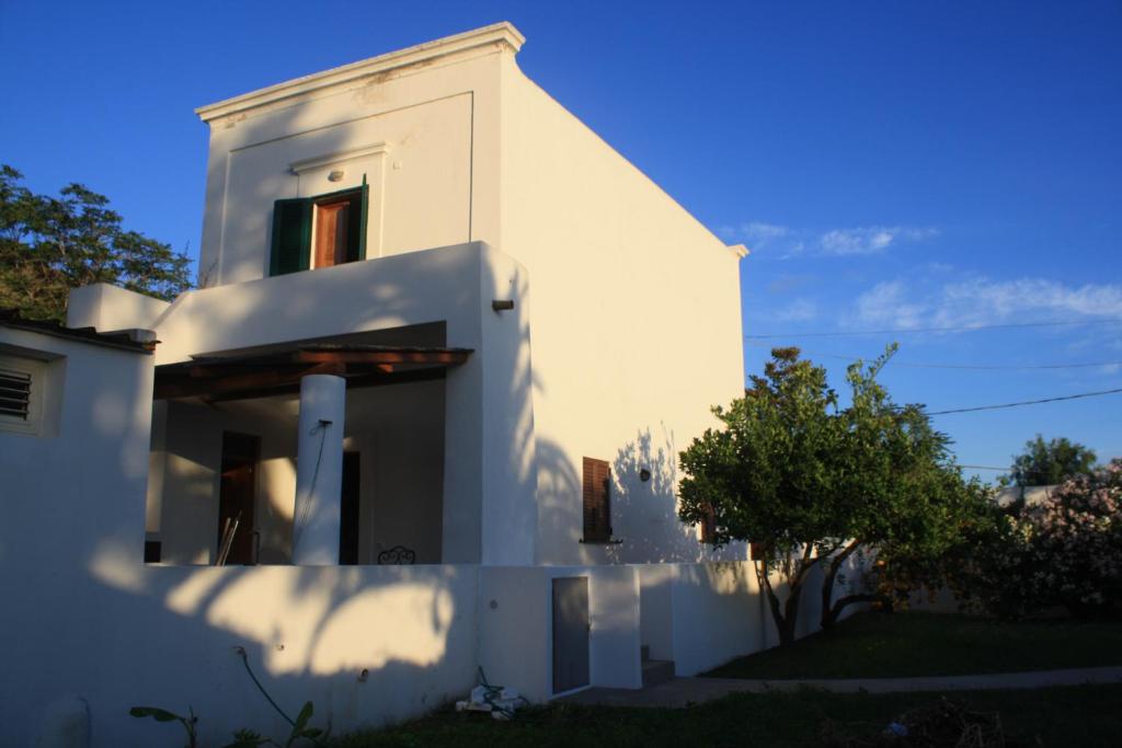 een wit huis met een witte muur en een boom bij Casa Galletta in Stromboli