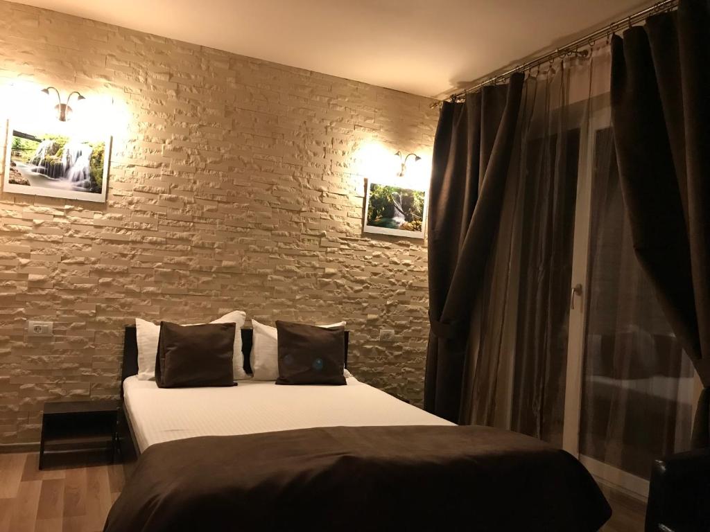 um quarto com 2 camas e uma parede de tijolos em Pensiune Muntii Aninei em Anina