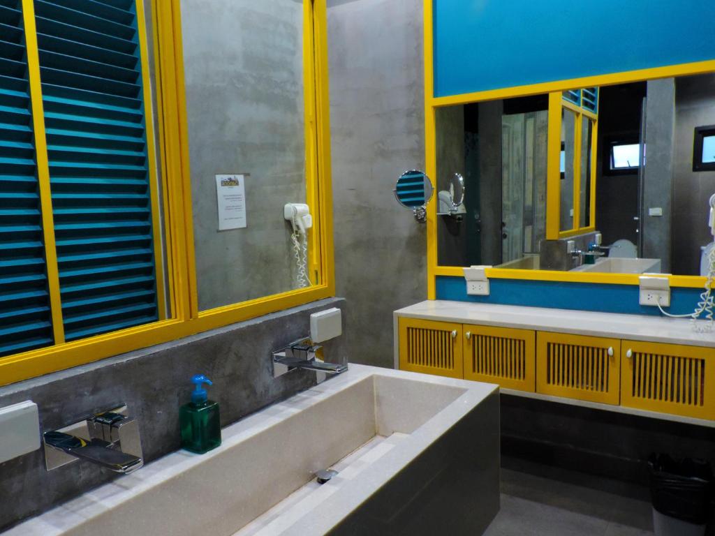 a bathroom with a large sink and two mirrors at iSanook Hostel in Bangkok