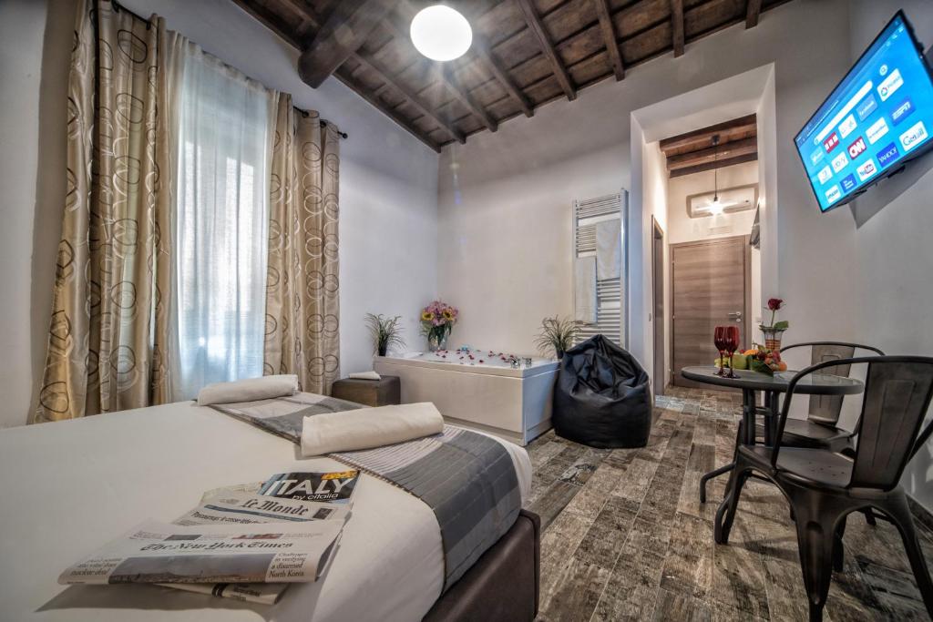 um quarto com uma cama, uma televisão e uma banheira em StarHome Navona em Roma