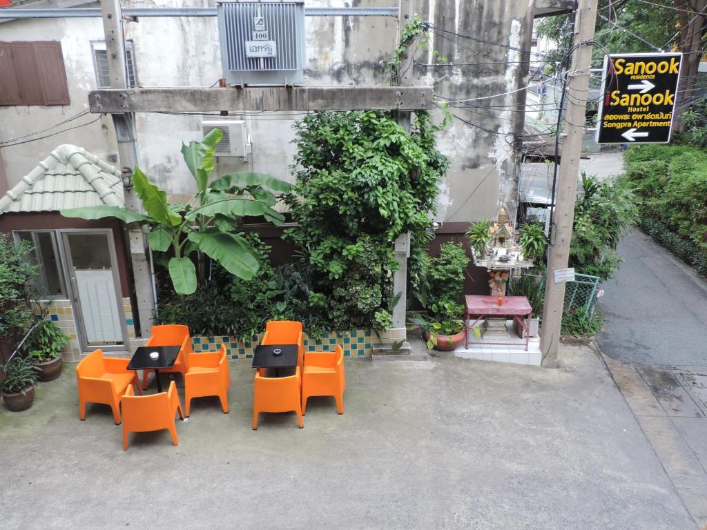 a group of chairs and tables in front of a building at iSanook Hostel in Bangkok