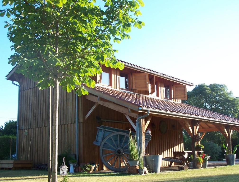 una gran casa de madera con una rueda grande en La Roulotte de la Vallée du Lot, en Le Temple-sur-Lot