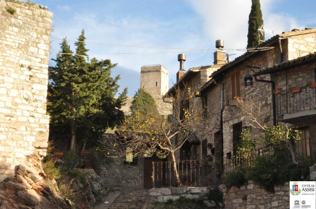 an old stone building with a castle in the background at Da Marzietta in Assisi