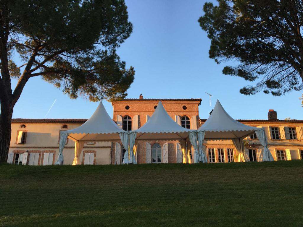 Tienda blanca frente a un edificio en Domaine de Gailhaguet B&B, en Verfeil