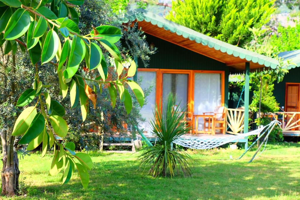 ein Haus mit einer Hängematte davor in der Unterkunft Etenna Beach Bungalows in Cıralı