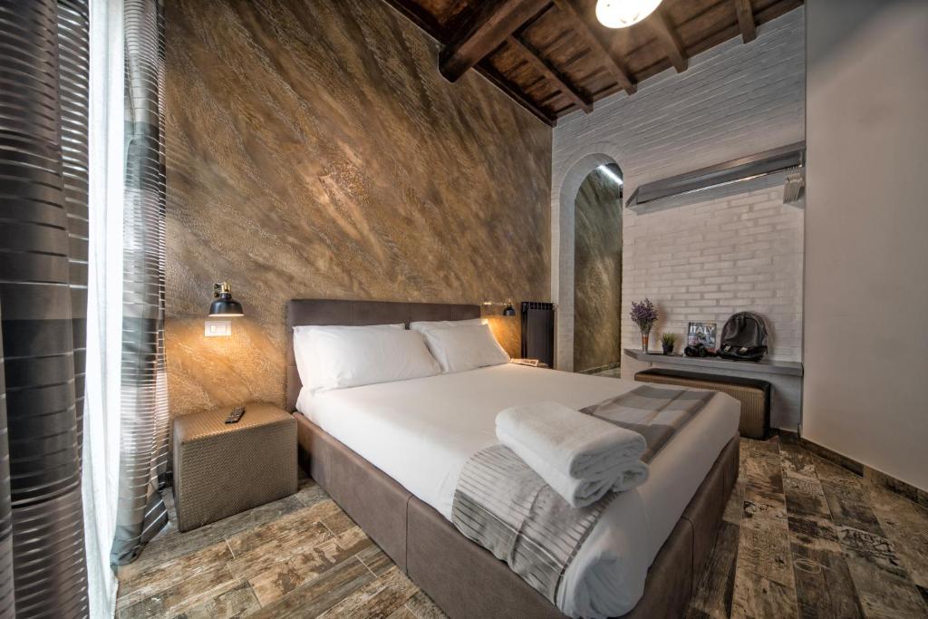 um quarto com uma cama grande e uma parede de tijolos em StarHome Navona em Roma