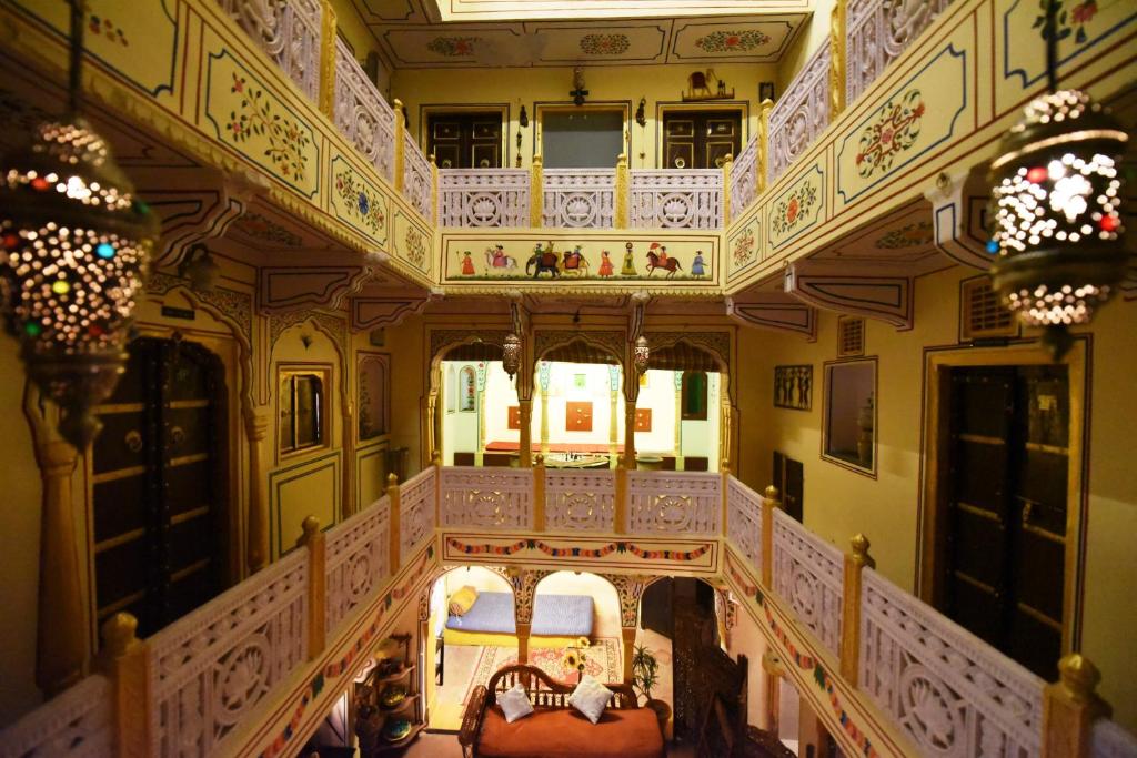 an ornate room with a balcony and a bed at Hotel Khandaka mahal in Jaipur