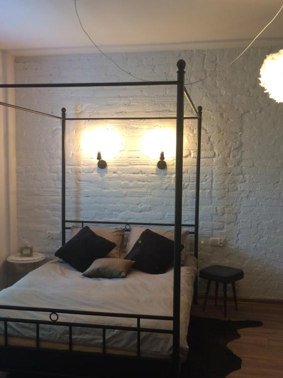 a bedroom with a canopy bed with a white brick wall at Apartament Ważka in Gdynia