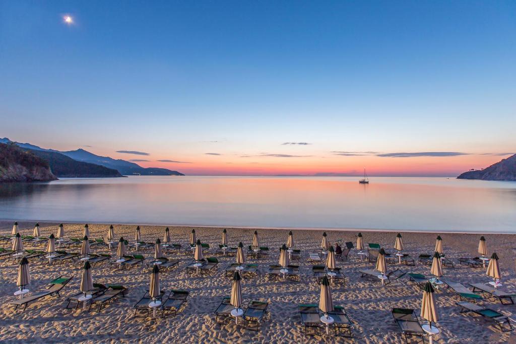 un gruppo di ombrelloni e sedie in spiaggia di Hotel Biodola a Portoferraio